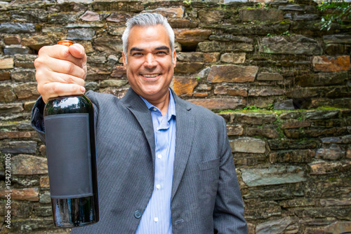 Professional latino matured Man Holding Out a Bottle of Wine