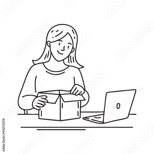 Someone unpacking a box beside a laptop