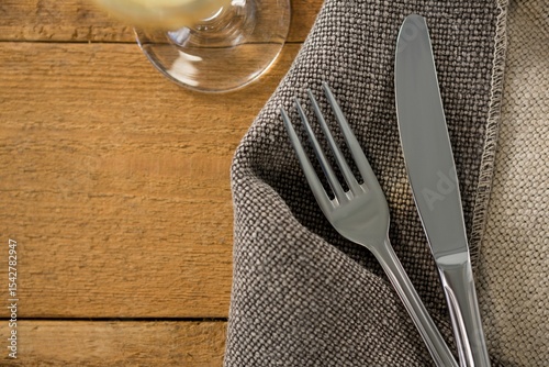 Fork and knife on sack at wooden table