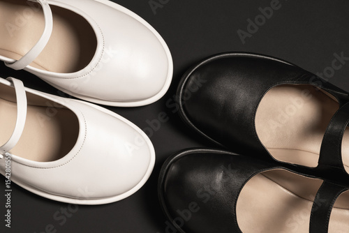 White and black shoes on black background with copy space.