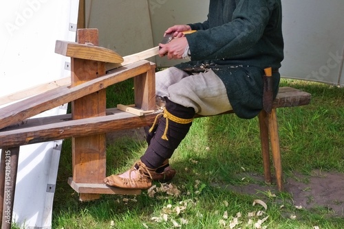 Medieval Archer Crafting a Wooden Bow. Craftsman in Viking Costume Working with Wood.