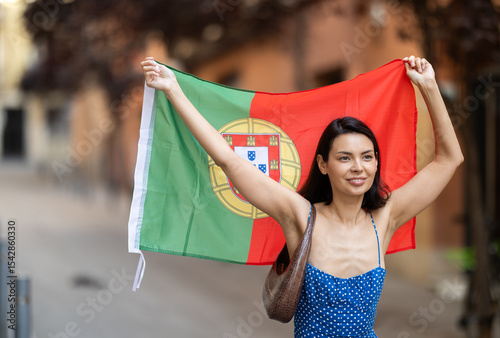 Young woman in summer dress with portuguese flag on city street