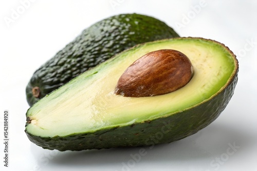 A pair of whole and partial avocados on a white background.