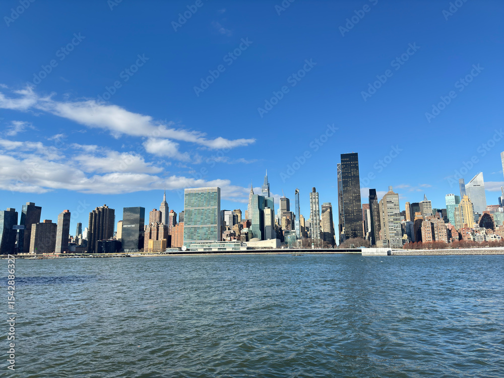Naklejka premium View of New York skyscrapers across the East River. United Nations Headquarters, Trump World Tower, etc.Clear Sky. From Gantry Plaza State Park in Long Island City.