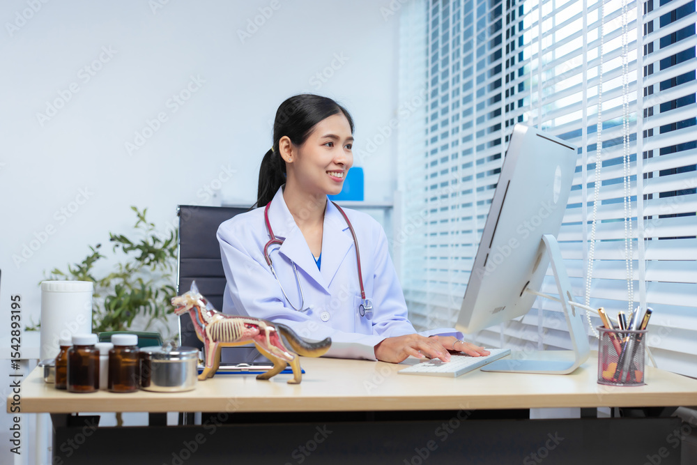 A confident Asian female veterinarian sits at her desk, providing online consultations. She uses computer and monitor to diagnose and advise pet owners, offering virtual care through animal clinic. A confident Asian female veterinarian sits at her desk, providing online consultations. She uses computer and monitor to diagnose and advise pet owners, offering virtual care through animal clinic.