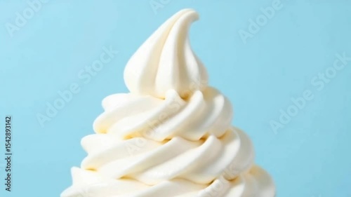 A soft-serve ice cream swirl on a light blue background.