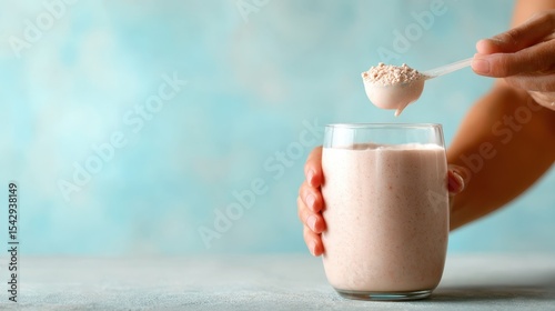 A delicious and nutritious protein shake being prepared with a scoop of protein powder. The glass features a creamy blend, perfect for post-workout recovery.