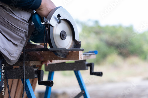 Carpenter Cutting Wood with Circular Saw in Outdoor Setting