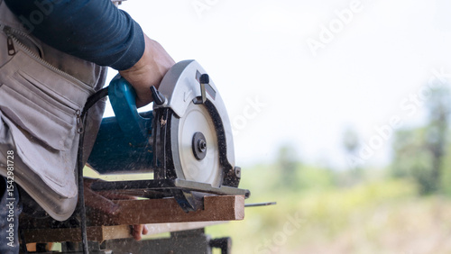 Carpenter Cutting Wood with Circular Saw in Outdoor Setting