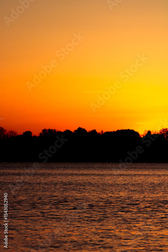 orange and yellow fiery sunset on the lake
