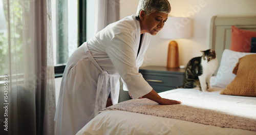 фотографія Woman, sheets and tidy bed in home for cleaning, morning habit and resting place for cat