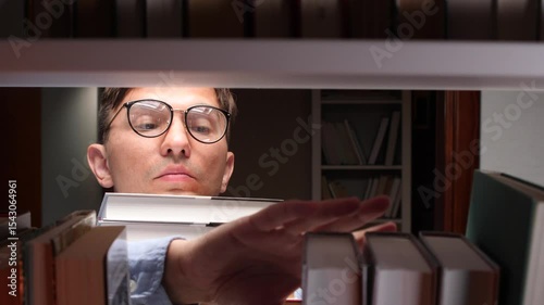 Librarian searching for book in library at night