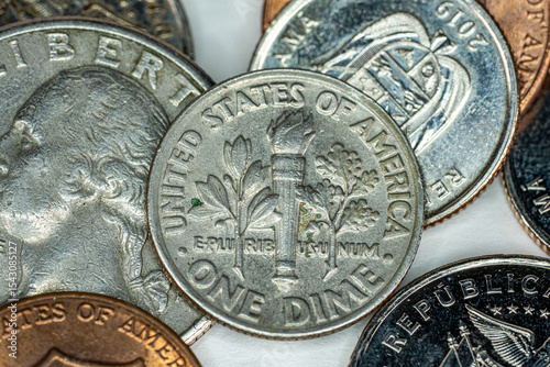 Tableau sur toile One dime US Dollar on top of different currency coins on white background macro