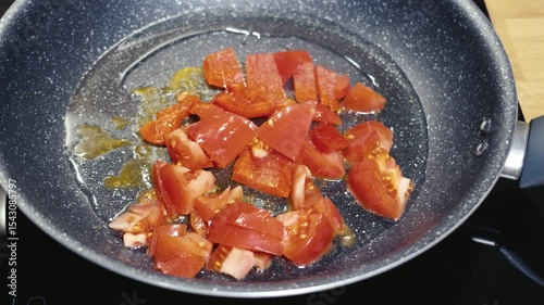 Cooking fresh tomatoes in a skillet for a delicious healthy meal at home