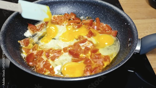 Delicious healthy breakfast preparation with fresh tomatoes and eggs in a cozy kitchen