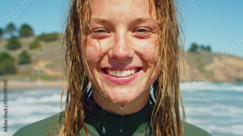 Beautiful surfer girl smiling and splashing the camera, healthy active lifestyle 