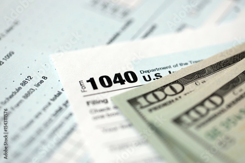 Hundred dollar bills and 1040 individual income tax return form blank close up. Few usd notes and united states tax blank. Concept of taxpaying and accounting in United States photo