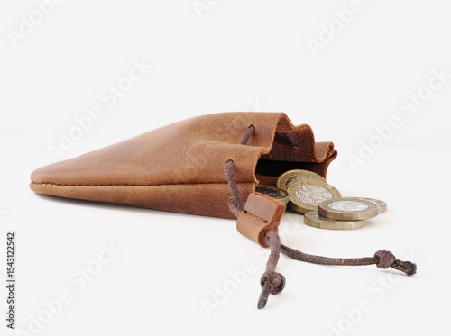 natural leather cow hide pig skin coin purse with draw cords  and loose coins isolated on a white background