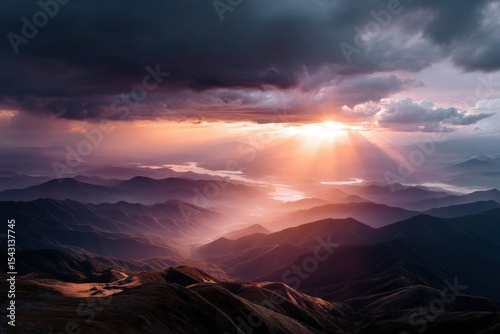Breathtaking mountain sunrise with dramatic skies and sunlight beams over valleys
