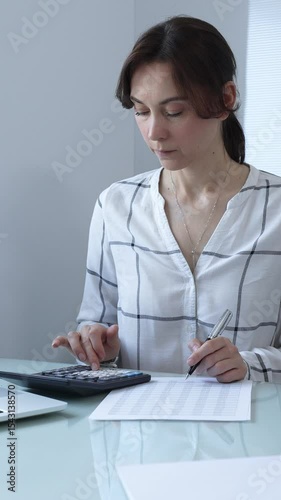 Female professional calculating finances, reviewing paperwork, tracking business expenses with precision and focus. Audit and taxes in business