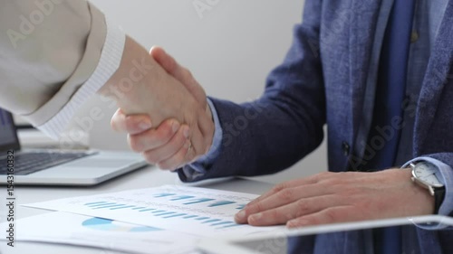 Business partners shaking hands at meeting after signing contract, finishing up collaboration or making successful deal. Business people concept