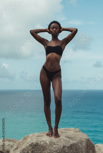 Black Woman in Matte Black Bikini on Granite Plateau Above Seychelles Beach