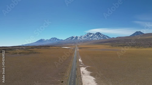 Erial view of an unbroken desert road leading to the mountainous horizon in northern Chile