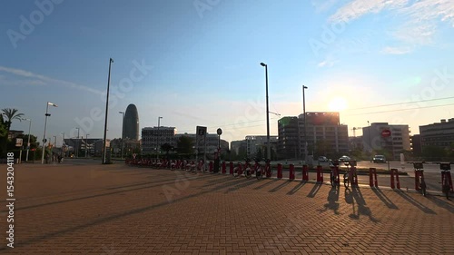 Golden sunlight bathing parked electric scooters near iconic agbar tower, capturing barcelona's urban morning landscape with warm, vibrant colors and innovative mobility infrastructure