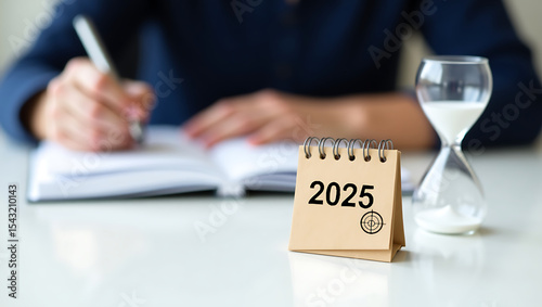 2025 Calendar Planning with Hourglass and Journal – Concept of Time Management and Goal Setting.