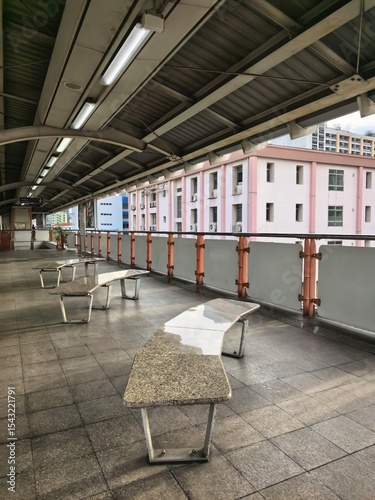 Empty public walkway with stone benches and modern architecture