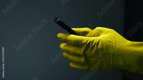 A man in yellow gloves clicks on the smartphone screen so as not to leave fingerprints.
Stolen phone in hands.
Unlocking your phone with gloves