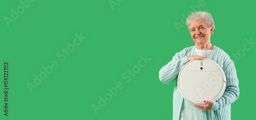 Senior woman with robot vac...