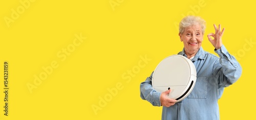 Senior woman with robot vac...