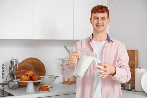 Young redhead man pouring m...