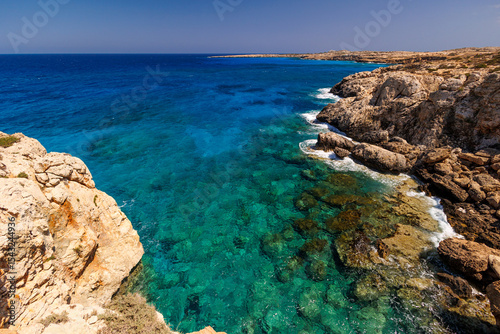 Rocky Coastline with Turquoise Water in Cyprus, Scenic view of a rugged rocky shoreline and crystal-clear turquoise sea on a sunny day. summer travel , hot summer 