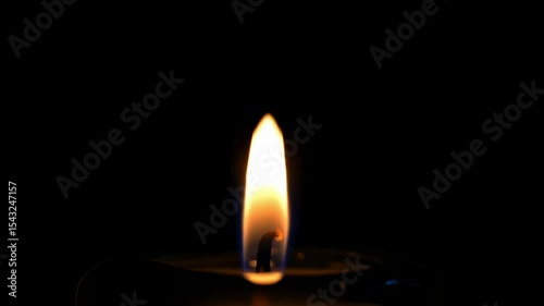 Candle flame against a dark background warm light glows