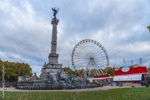 Monument aux girondins with ferris wheel in quinconces esplanade, bordeaux, france photo