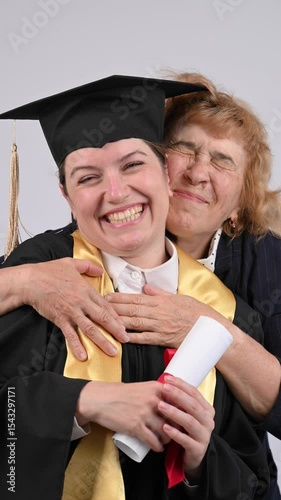 Portrait of Caucasian woman in graduation gown with her mother. 
