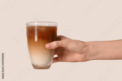 Female hand with glass of iced latte on white background