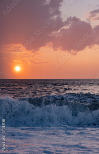 Soft purple and orange clouds, big sea wave