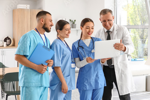 Medical team collaboration with laptop, healthcare professionals discussing p...