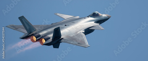 Advanced military aircraft in flight with engines glowing and sky backdrop