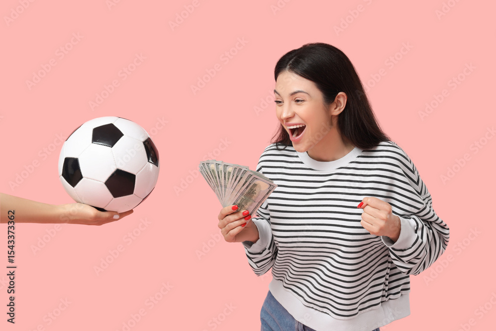 Happy young woman holding money and hand with soccer ball on pink background. Sports bet concept Happy young woman holding money and hand with soccer ball on pink background. Sports bet concept
