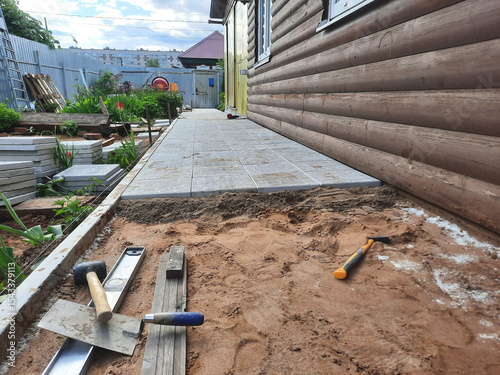 The blind area along the house is laid with tiles. Construction of the sidewalk