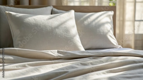 Soft bedding with white pillows and natural light creating a cozy atmosphere.