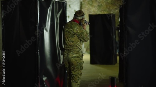 Military training exercise highlighting tactical maneuvers in an indoor arena with various obstacles and cover spots