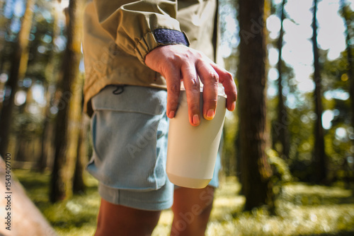 Outdoor Adventure Featuring Hand Holding Eco-Friendly Cup in Lush Forest