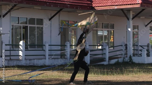 Man in black releases a kite into the sky