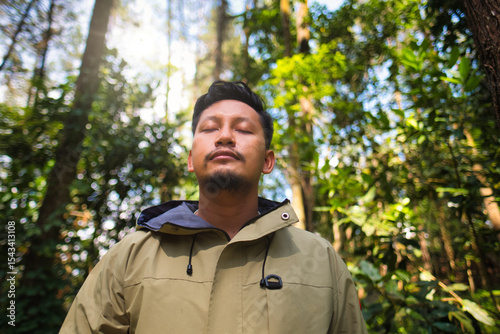 Man Relaxing in Forest With Sunlight Passing Through Trees