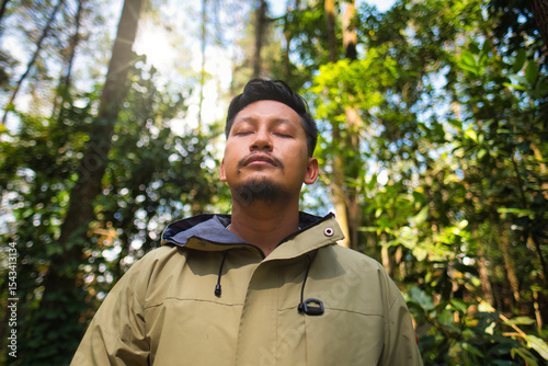 Man Relaxing in Forest With Sunlight Passing Through Trees